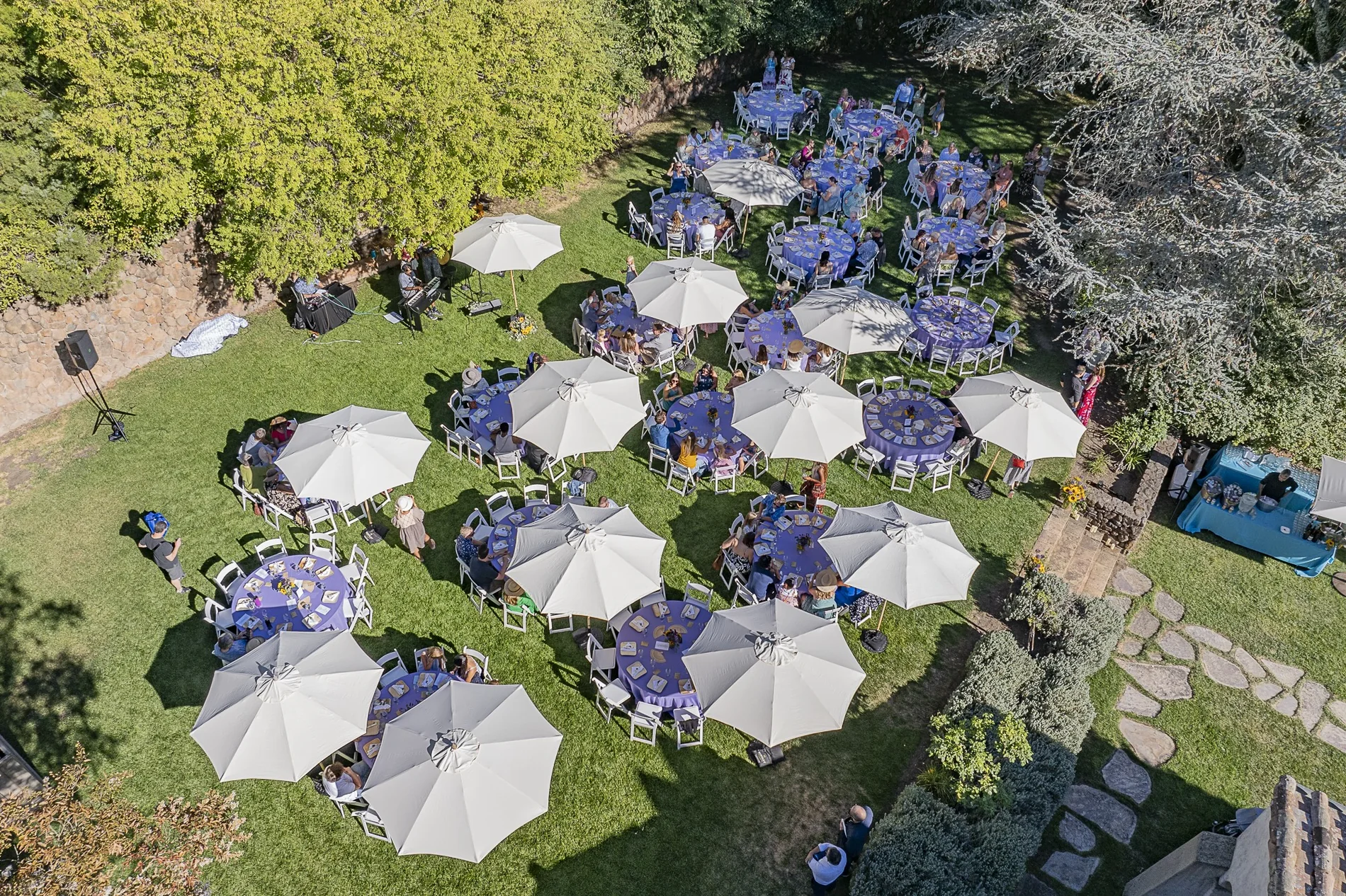Harvest of the Heart guests gathered at tables in the garden